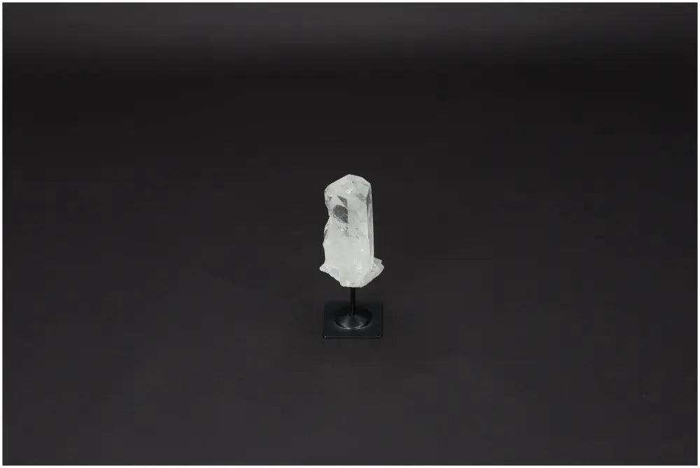 Lemurian Quartz on metal stand against dark background, highlighting its clarity and purification properties.