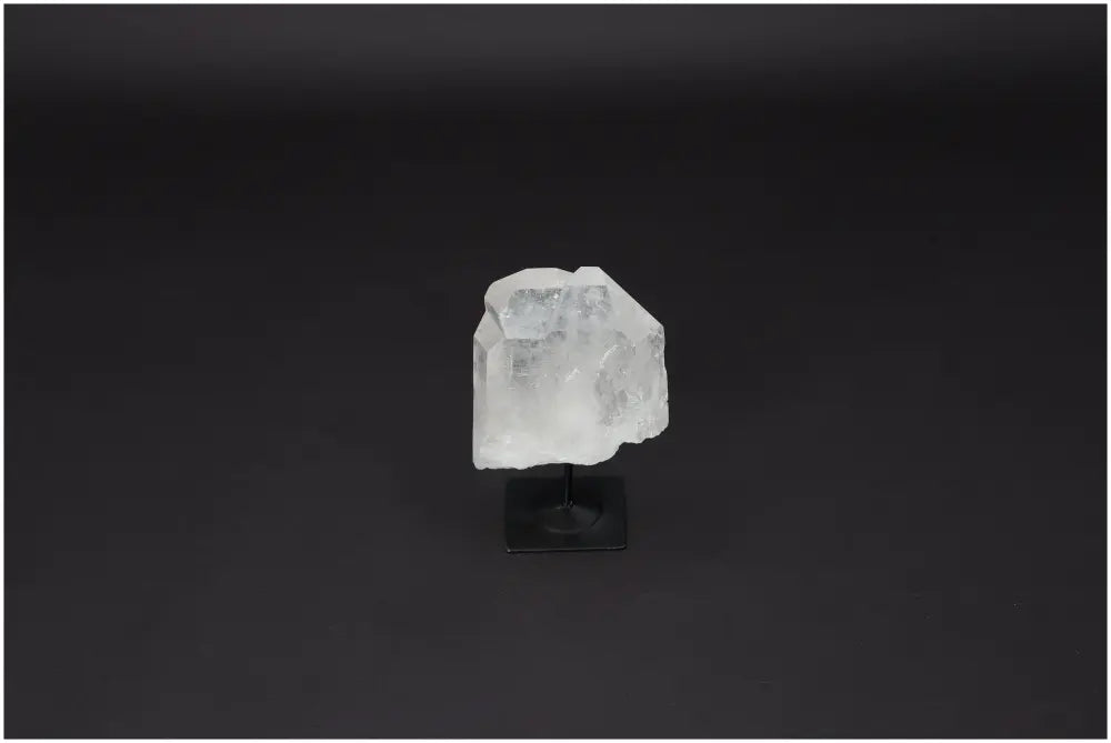 Lemurian quartz crystal on metal stand, ideal for energy purification and neutralizing negative vibrations, against dark background