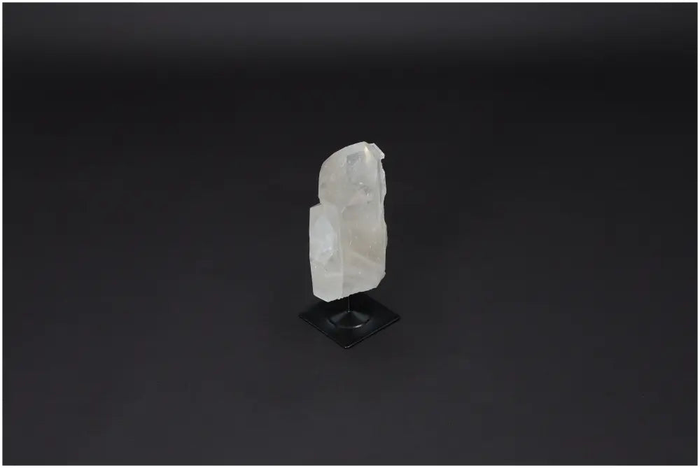 Lemurian Quartz on metal stand displayed on black background, showcasing its clarity and subtle energy harmonizing features.