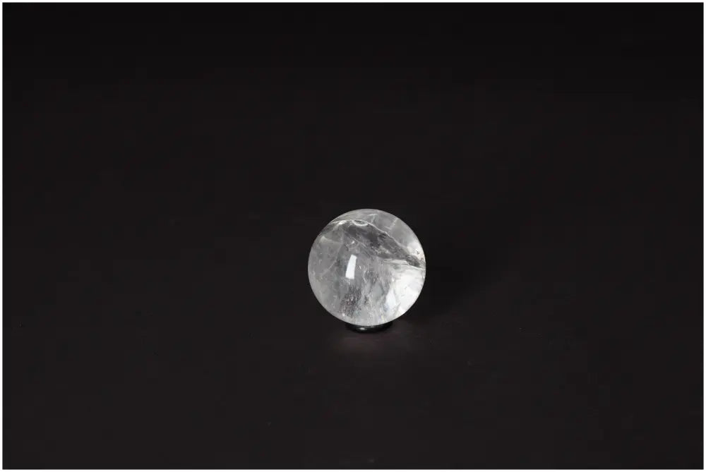 Lemurian Quartz Sphere 3-4 CM on dark background, showcasing its luminous clarity and subtle horizontal striations for spiritual growth.