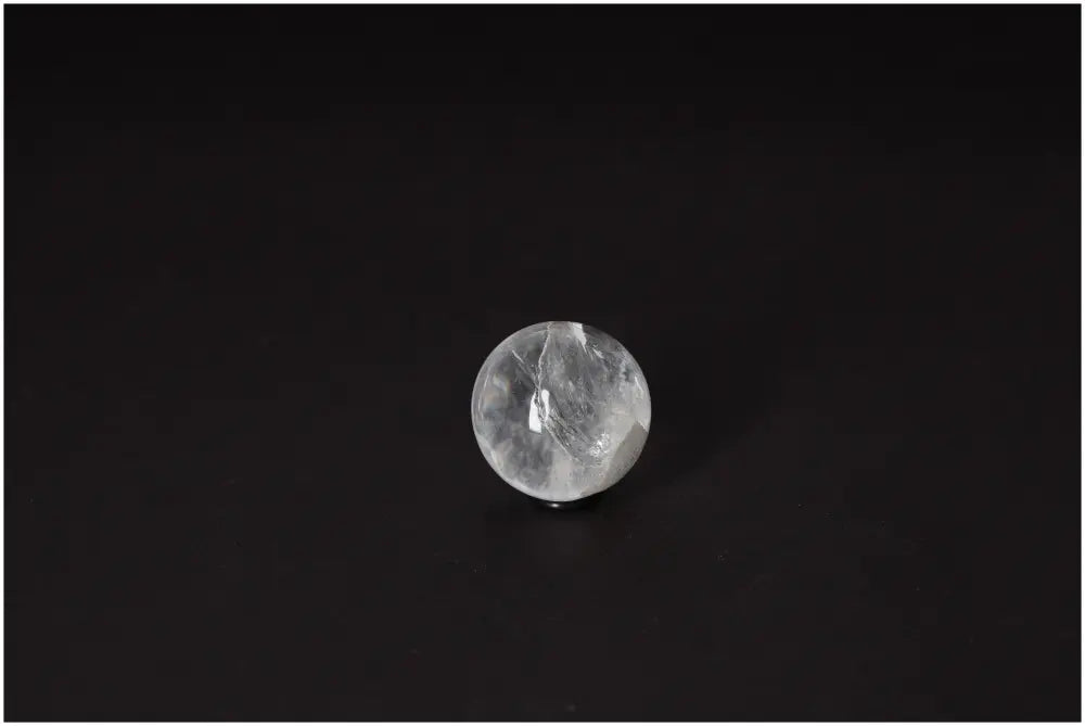 Lemurian Quartz Sphere on black background showcasing its luminous clarity and subtle horizontal striations, size 3-4 cm.