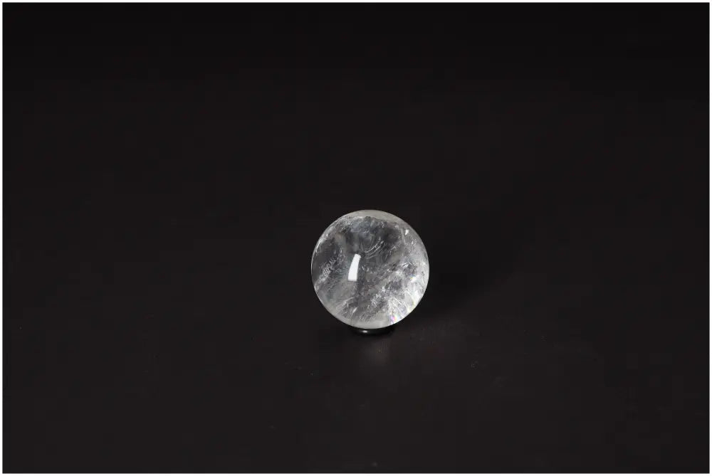 Lemurian Quartz Sphere 3-4 CM with luminous clarity, promoting intuition and spiritual growth on a dark background.