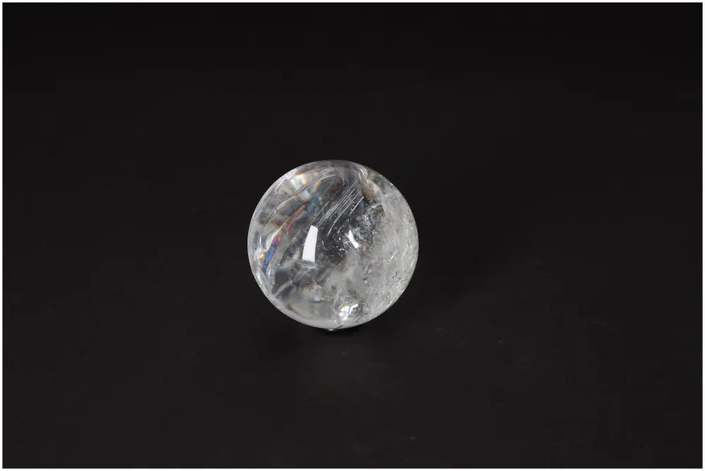 Lemurian Quartz Sphere on black background showcasing clarity and subtle striations, embodying ancient wisdom and high-vibrational energy.