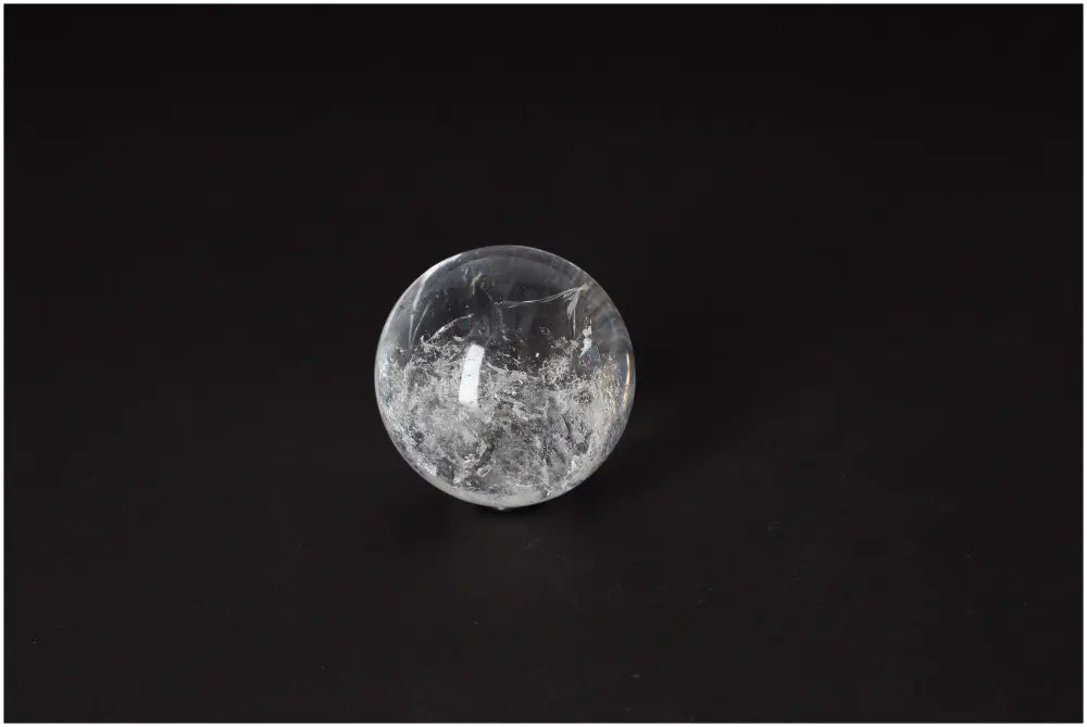 Lemurian Quartz Sphere 5-6 CM on dark background, showcasing its luminous clarity and subtle striations, perfect for spiritual growth.