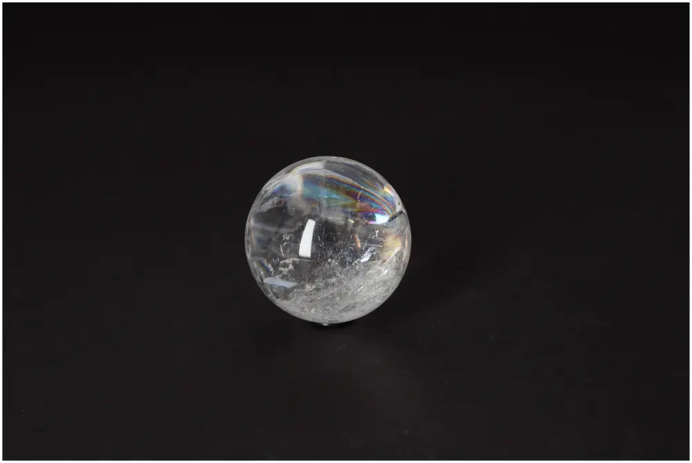 Lemurian Quartz sphere on black background, showcasing its luminous clarity and subtle striations. Promotes intuition and spiritual growth.