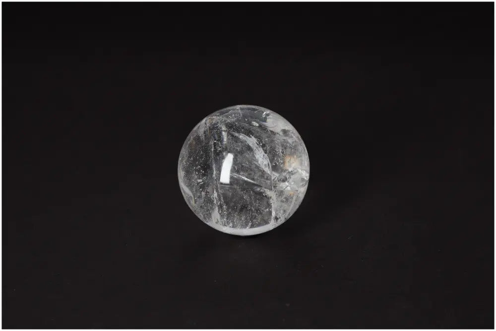 Lemurian Quartz Sphere 6-7 CM, radiating high-vibrational energy, with horizontal striations and clear clarity on a dark background.
