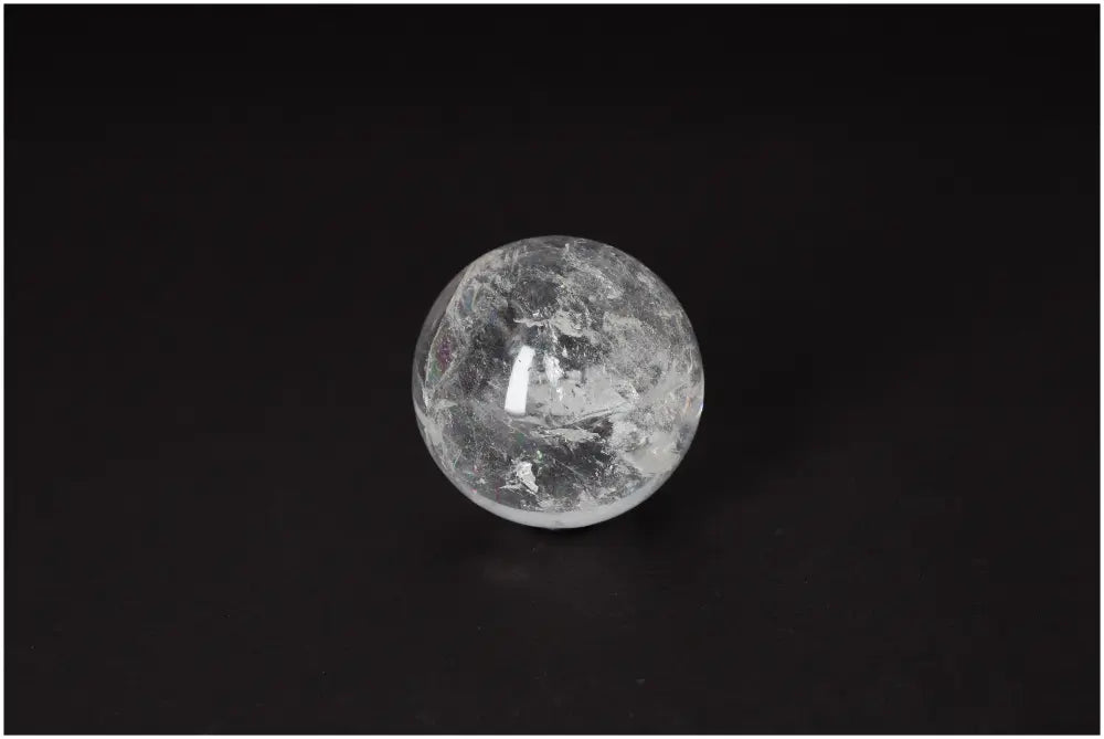 Clear Lemurian Quartz Sphere 6-7 CM on black background, showcasing luminous clarity and ancient energy