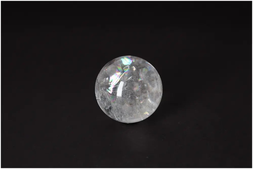 Clear Lemurian Quartz Sphere 6-7 CM on black background, showcasing high-vibrational energy and luminous clarity for spiritual growth.