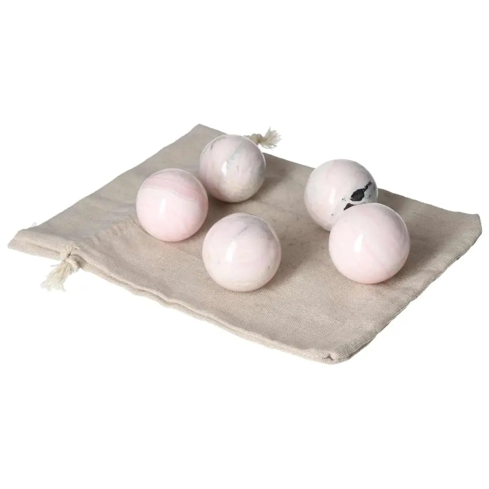 Manganocalcite spheres on a beige cloth, offering healing and creativity benefits.