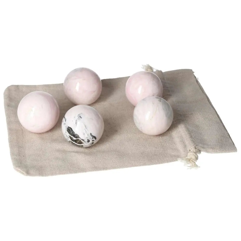 Manganocalcite spheres on a beige cloth, known for clearing negative energy and boosting creativity and calmness.