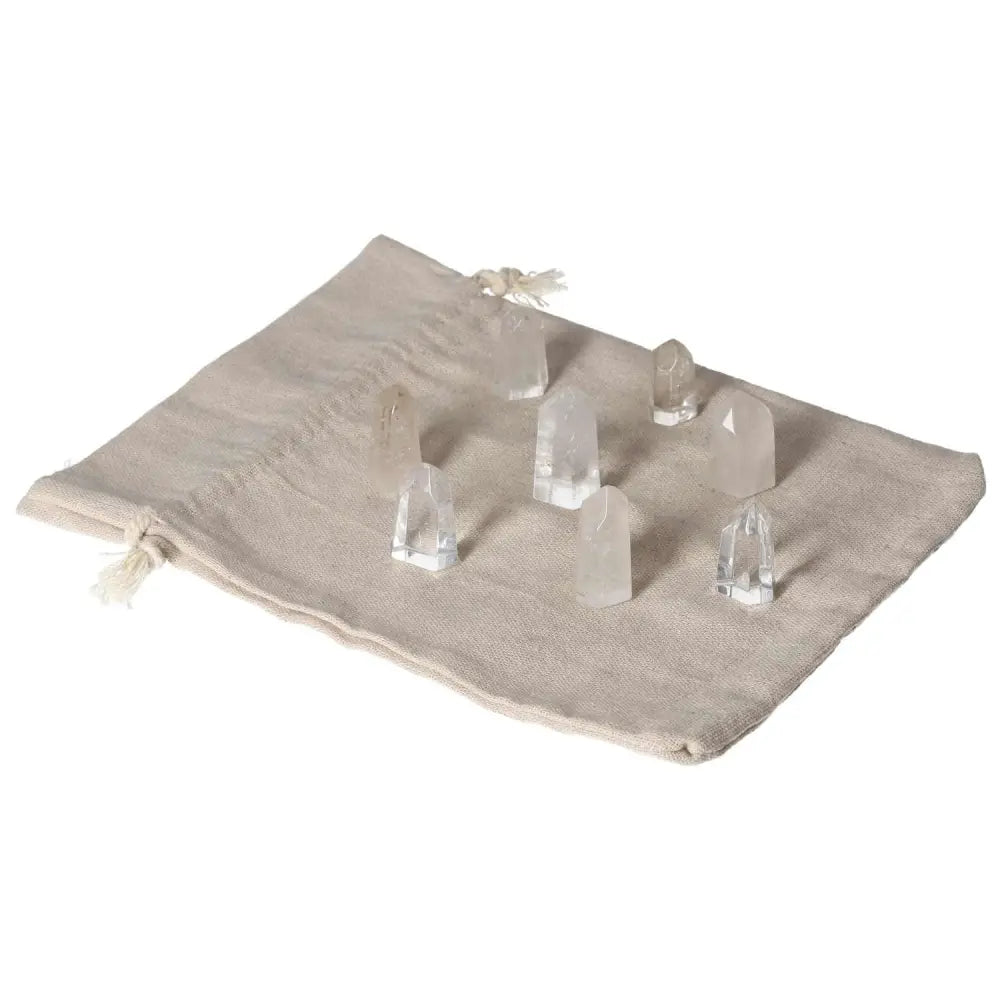 Mini Point Clear Quartz crystals arranged on a beige cloth, showcasing their clarity and energy-amplifying properties.