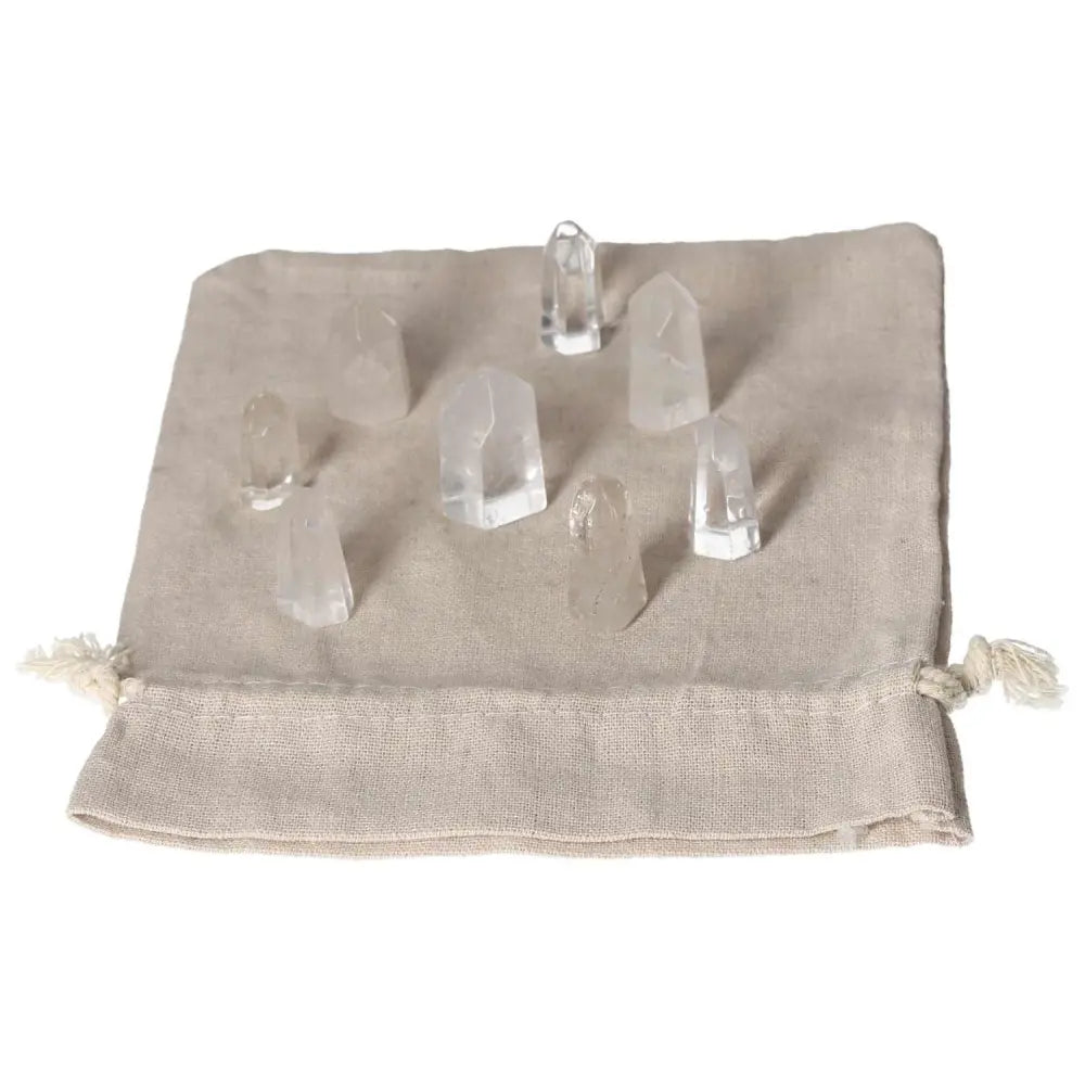 Mini Point Clear Quartz crystals on beige cloth, enhancing energy, focus, and spiritual growth. Perfect for crystal collections.