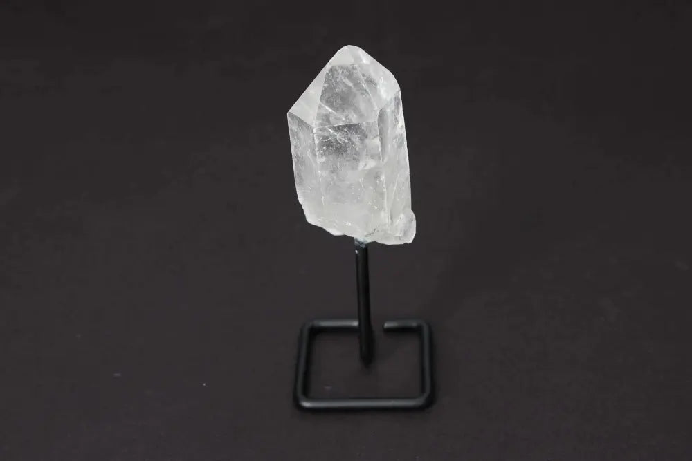 Natural Clear Quartz Point on stand for energy amplification and clarity in meditation and manifestation practices.
