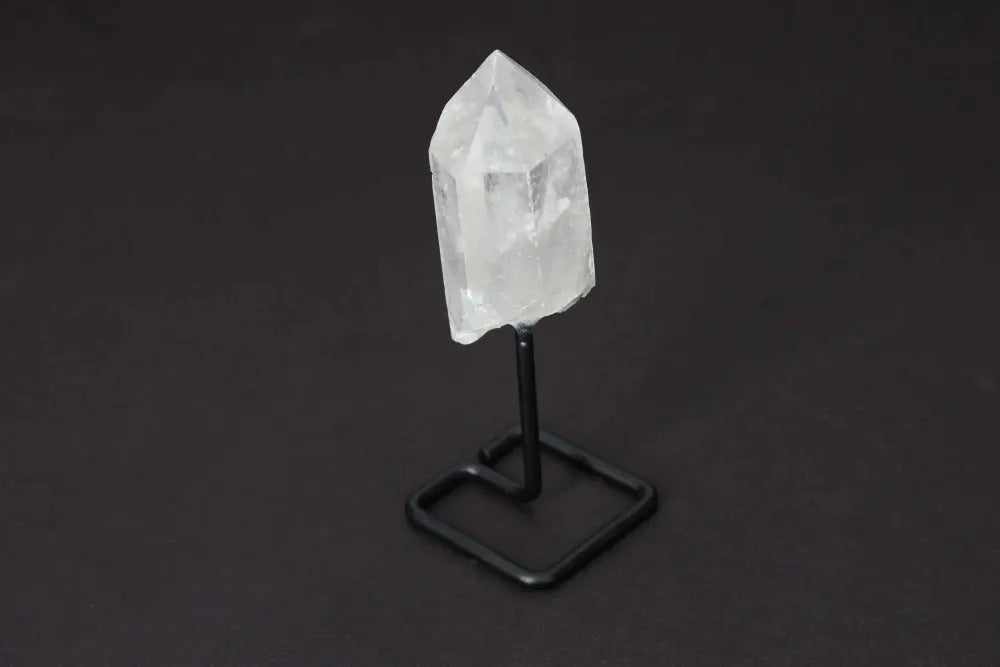 Natural Clear Quartz point on modern stand, known for amplifying energy and clarity, perfect for meditation and manifestation.