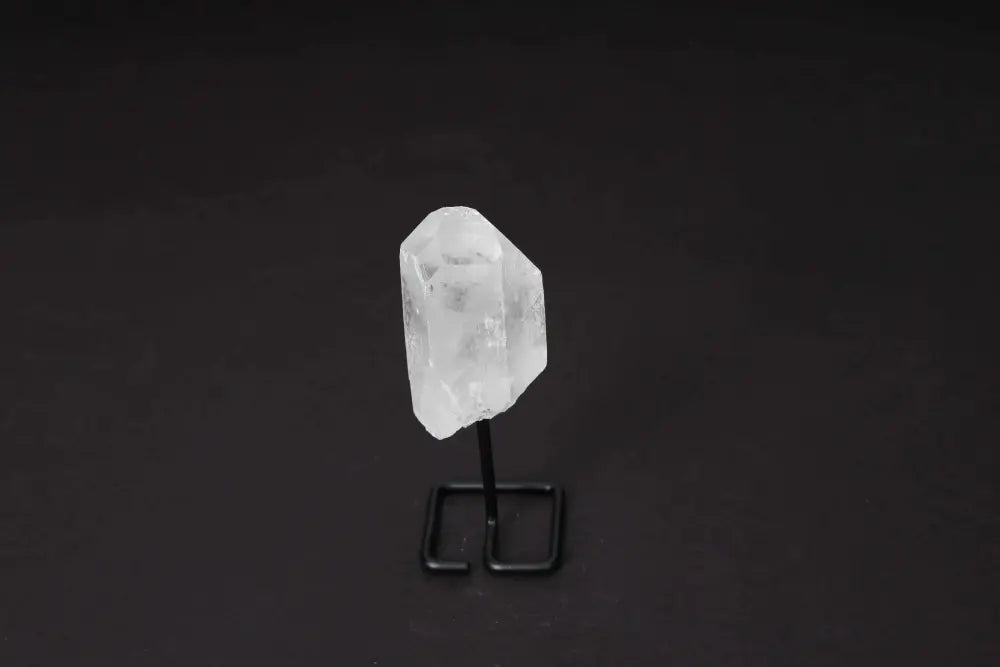 Natural Clear Quartz Point with stand on dark background, ideal for meditation and energy work, amplifying and aligning intentions.