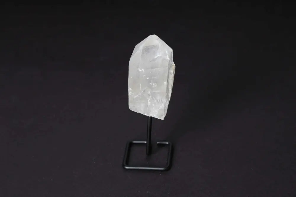 Natural Clear Quartz Point on a stand, enhancing energy and clarity, perfect for meditation and home decor.