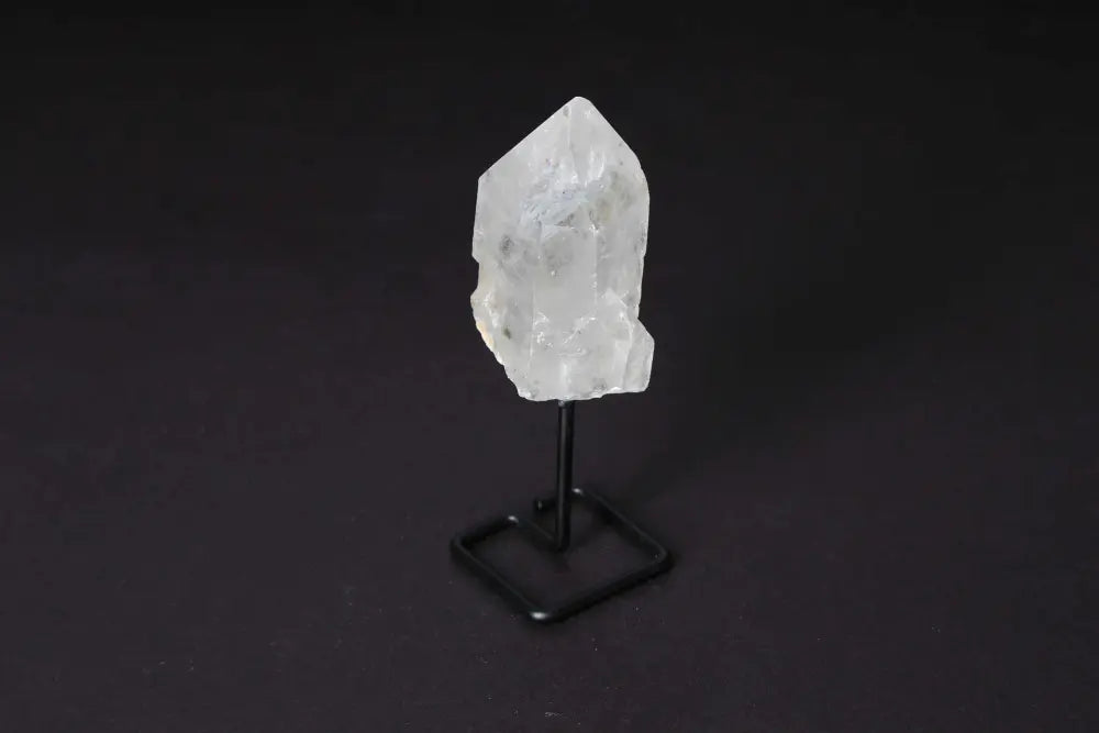 Clear quartz point on modern stand for energy amplification and focus in meditation or manifestation, elegant decor piece.