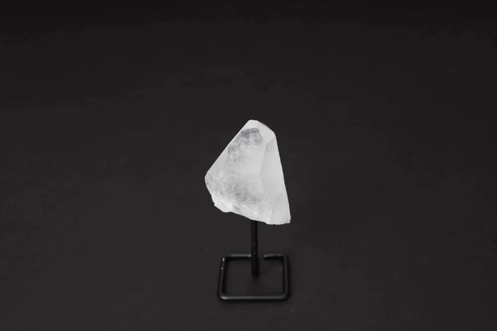 Natural Clear Quartz Point on Stand for energy alignment and meditation, elegantly displayed to amplify and illuminate space.