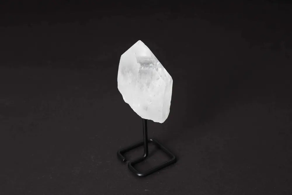 Natural Clear Quartz Point on stand, amplifying energy and clarity, ideal for meditation and manifestation, displayed on elegant stand.