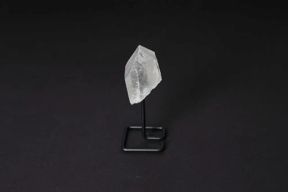 Natural Clear Quartz Point on a stand, known for energy amplification and clarity, ideal for meditation and manifestation.