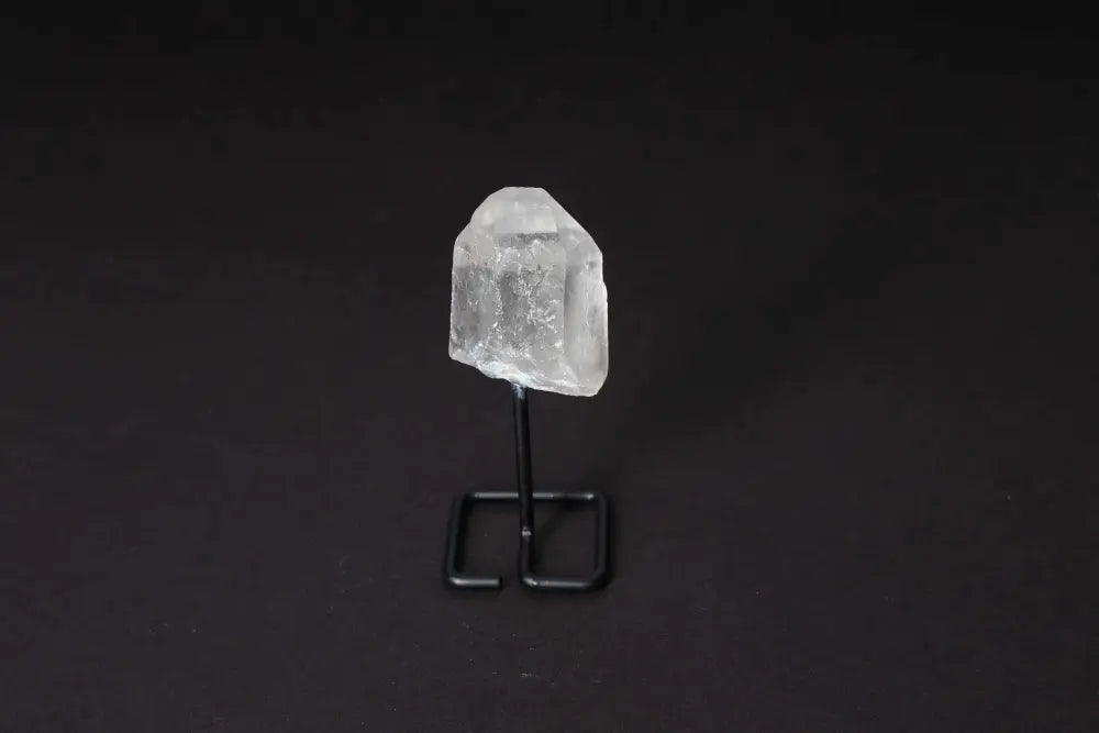 Natural Clear Quartz Point on modern stand for energy amplification and meditation, enhancing clarity and intention.
