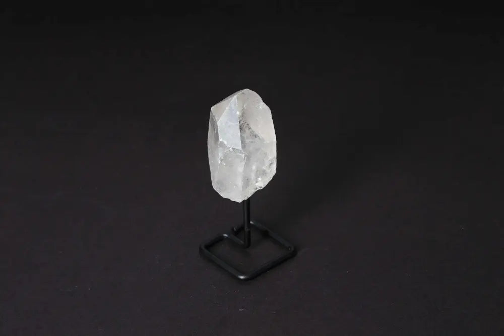 Natural Clear Quartz point displayed on a modern stand, ideal for energy amplification and meditation.