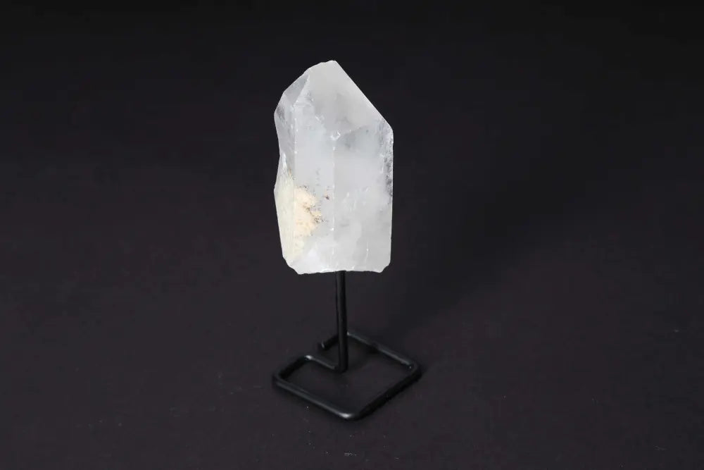 Natural clear quartz point on modern stand, enhancing energy and clarity, ideal for meditation and manifestation in any space.