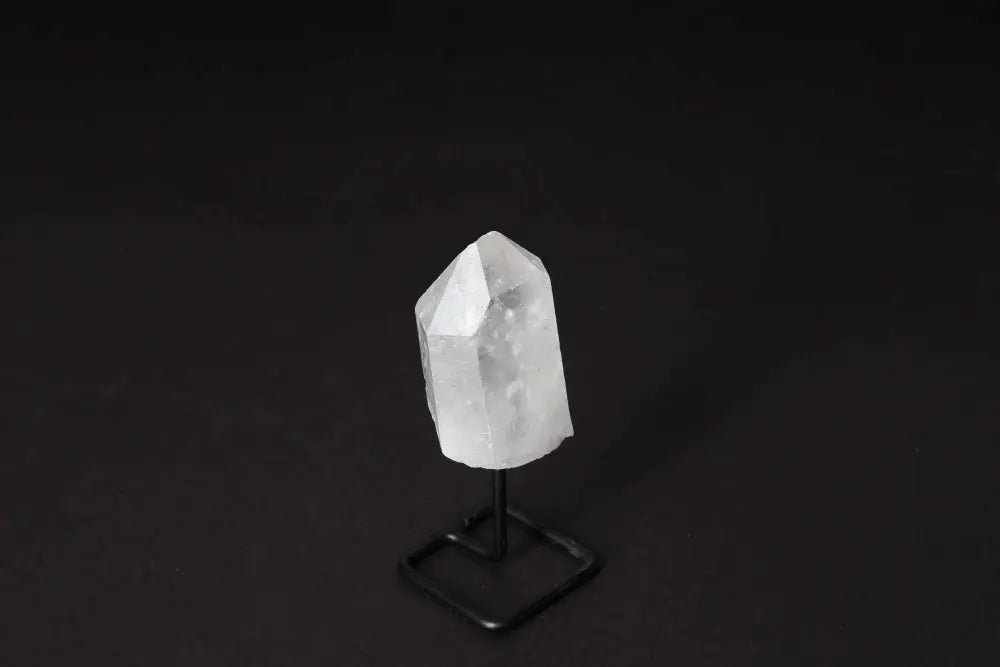 Natural Clear Quartz Point on a modern stand, ideal for energy amplification, meditation, and clarity in any space.