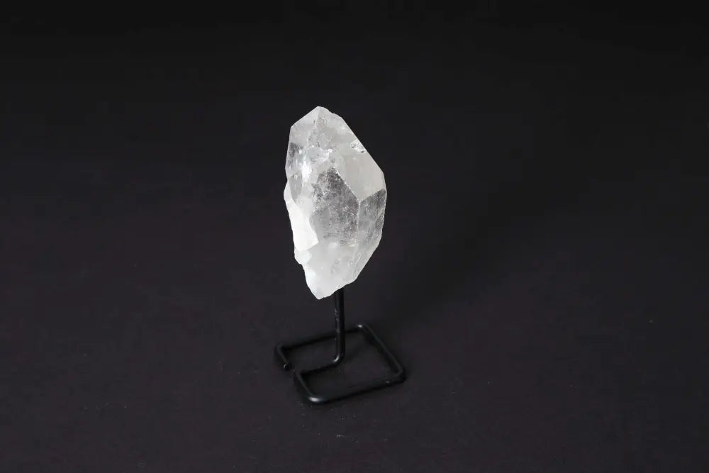 Natural Clear Quartz Point With Stand for energy amplification and alignment, elegantly displayed on a modern black stand.