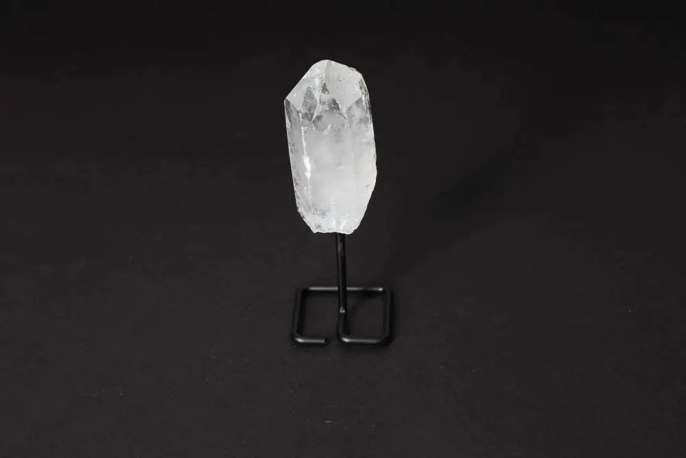 Clear Quartz Point on a black stand, ideal for amplifying energy and enhancing clarity in meditation and energy work.