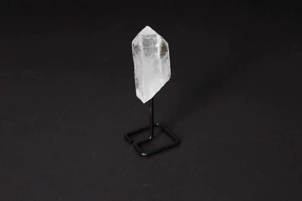 Natural Clear Quartz point on modern stand, ideal for meditation and energy work, boosting clarity and focus.