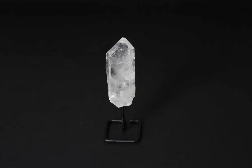 Natural Clear Quartz Point on stand, known as Master Healer, for amplifying energy and intention, ideal for meditation and clarity.