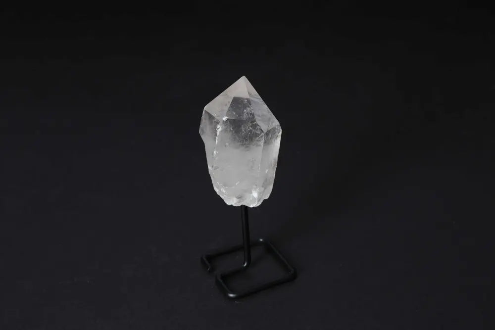 Natural Clear Quartz Point on a sleek black stand enhancing energy, focus, and clarity, ideal for meditation and manifestation.