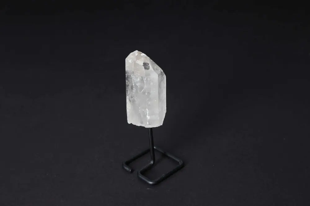 Natural Clear Quartz Point on a modern stand, ideal for amplifying energy and clarity in meditation and manifestation practices.