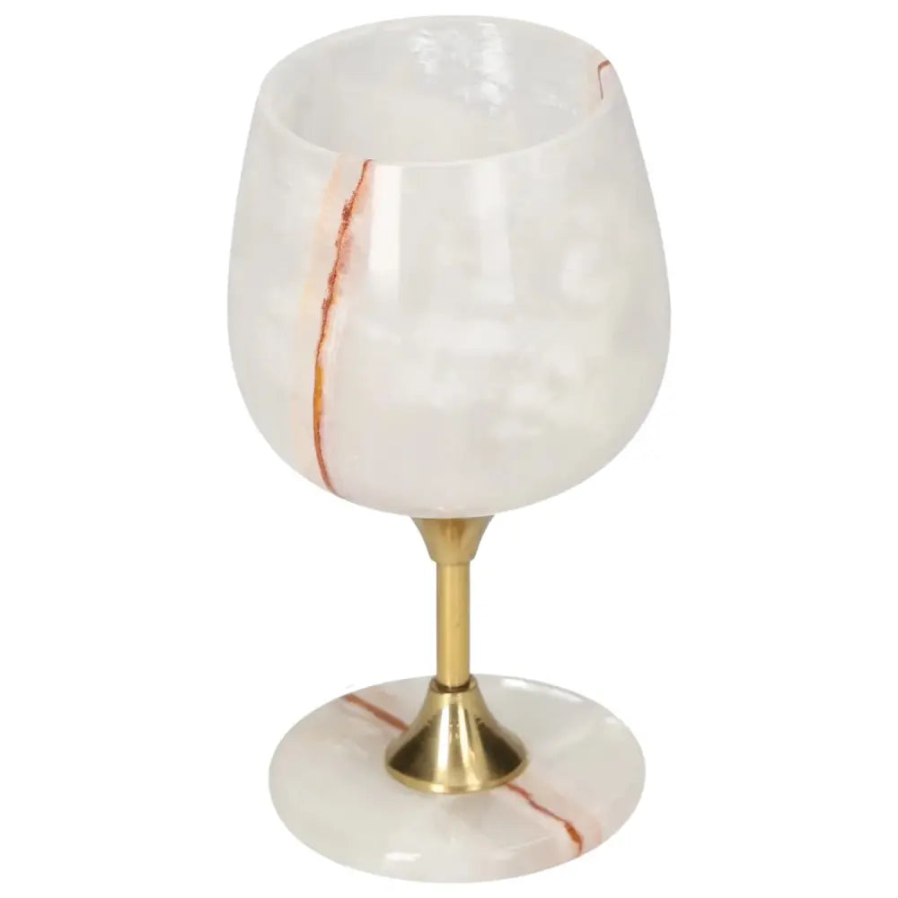 Elegant off-white onyx wine glass with unique veining and polished gold stem, perfect for sophisticated dining.