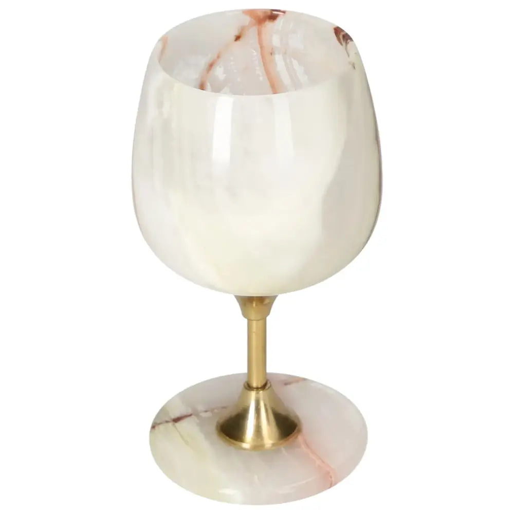 Exquisite onyx wine glass with unique veining, featuring a polished off-white surface and a brass stem for elegant sophistication.