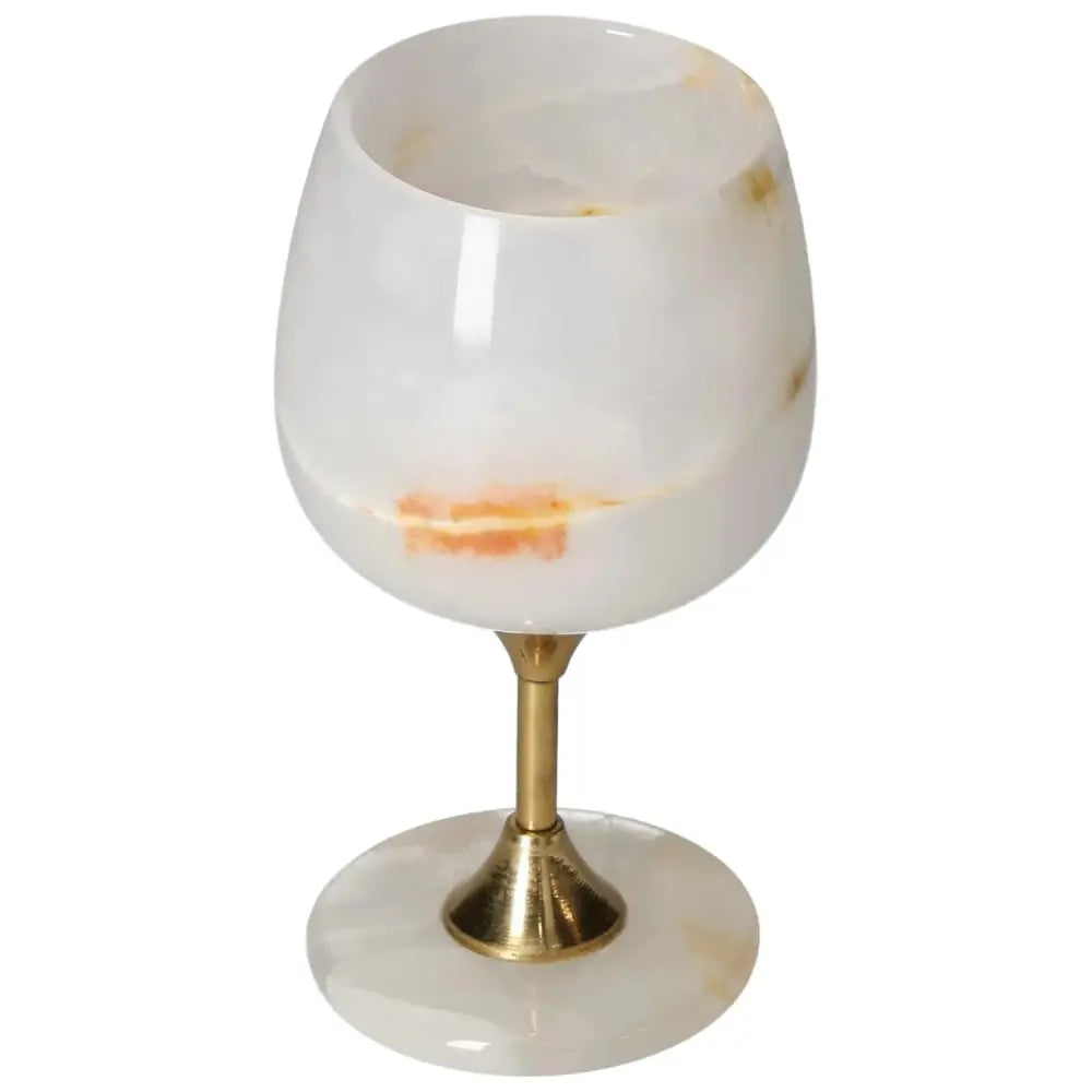 Elegant off-white onyx wine glass with unique veining and brass stem, showcasing fine craftsmanship and sophistication.