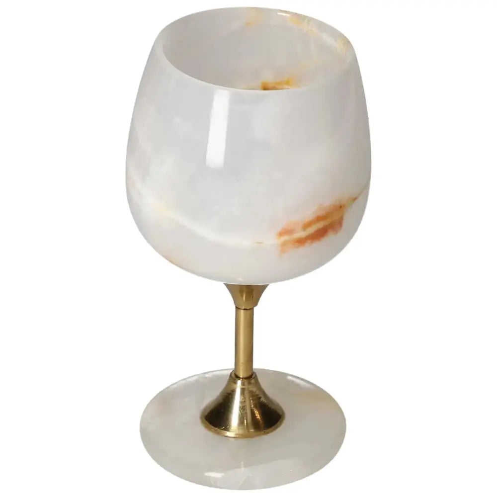 Exquisite onyx wine glass with off-white color and unique veining, featuring a polished surface and elegant brass stem.
