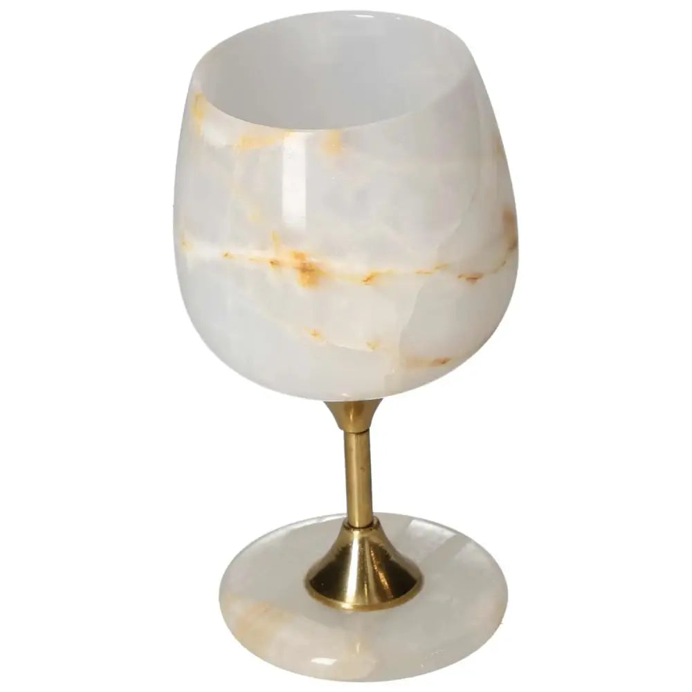 Exquisite onyx wine glass with unique off-white veining, polished surface, and elegant design on a golden stem, perfect for fine dining.