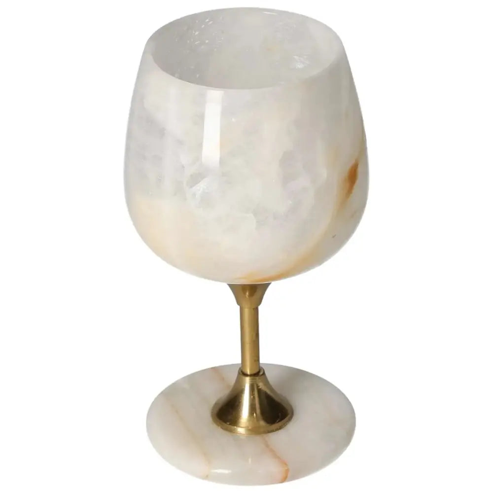 Exquisite off-white onyx wine glass with unique veining and polished finish, featuring a gold-toned stem for elegant dining.