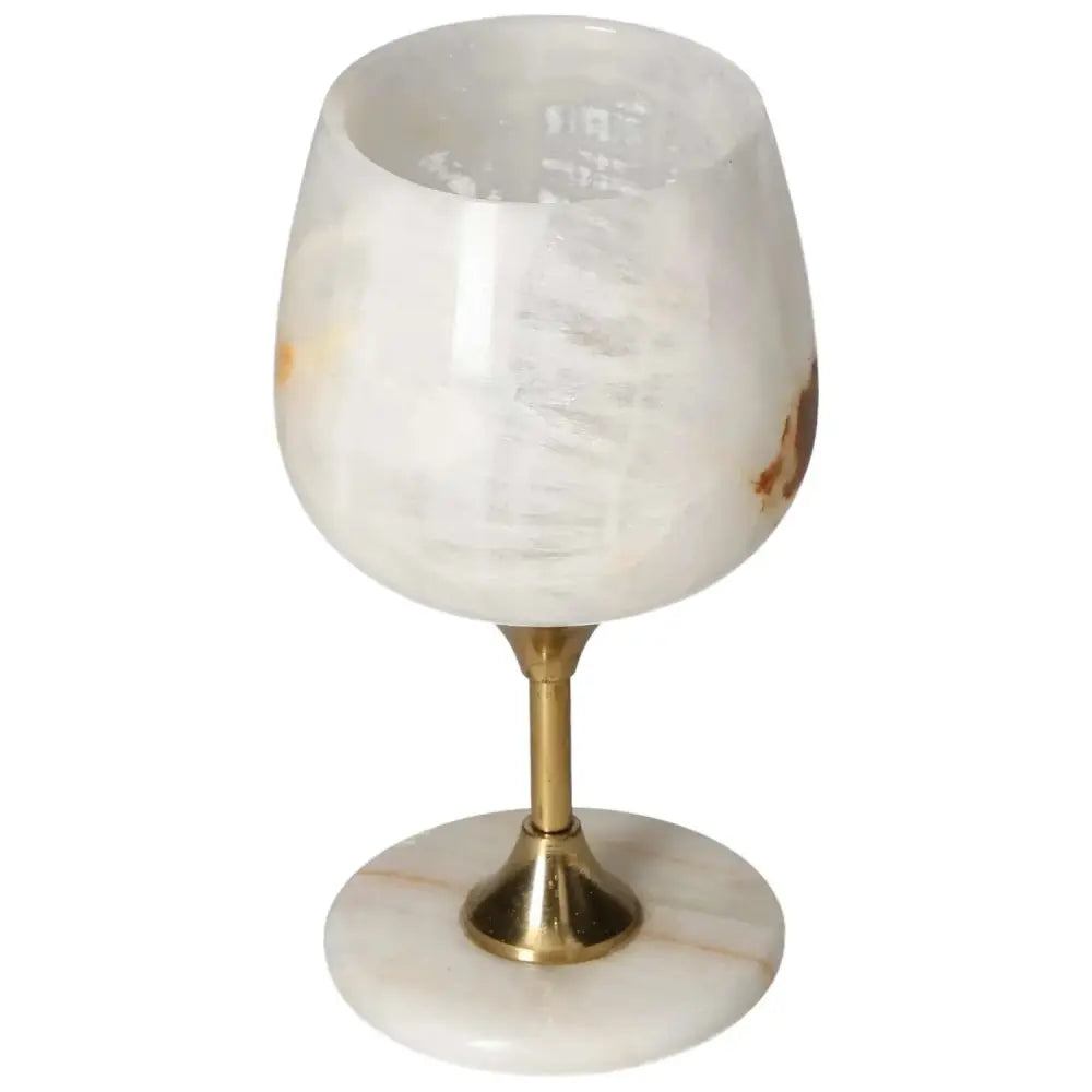 Elegant onyx wine glass with off-white hues and unique veining, paired with a polished gold stem, epitomizing luxury and sophistication.