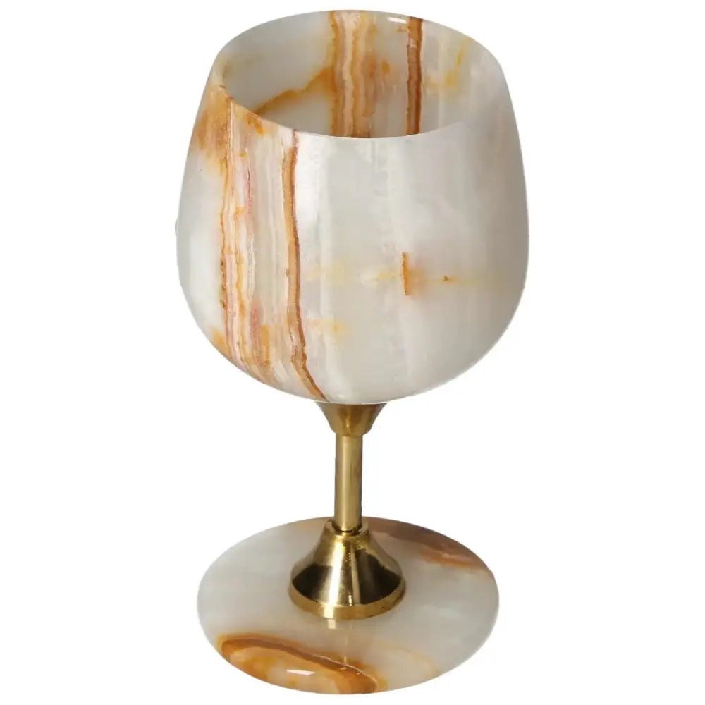Off-white onyx wine glass with unique veining, featuring a gold stem; perfect blend of elegance and sophistication for fine dining.