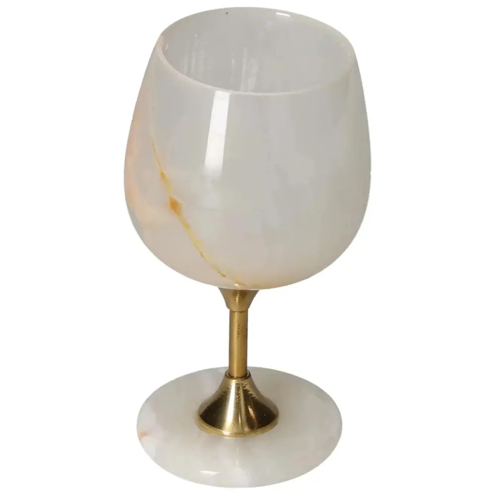 Elegant onyx wine glass with polished off-white surface and unique veining, set on a gold stem, perfect for sophisticated gatherings.