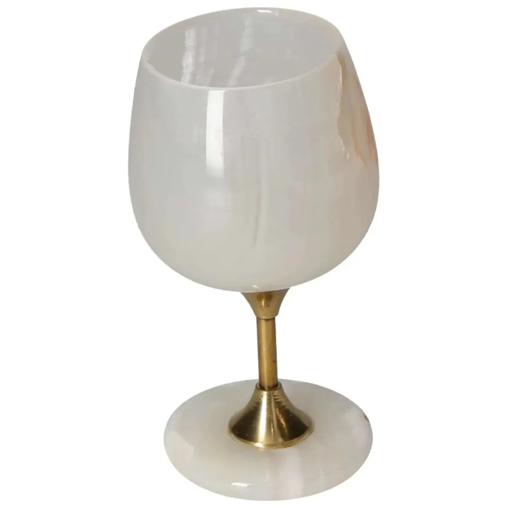Elegant onyx wine glass with unique veining on a polished surface and gold stem, perfect for sophisticated occasions.