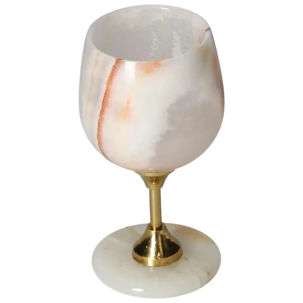 Exquisite onyx wine glass with a polished surface, showcasing unique off-white tones and veining, accented with a golden stem.