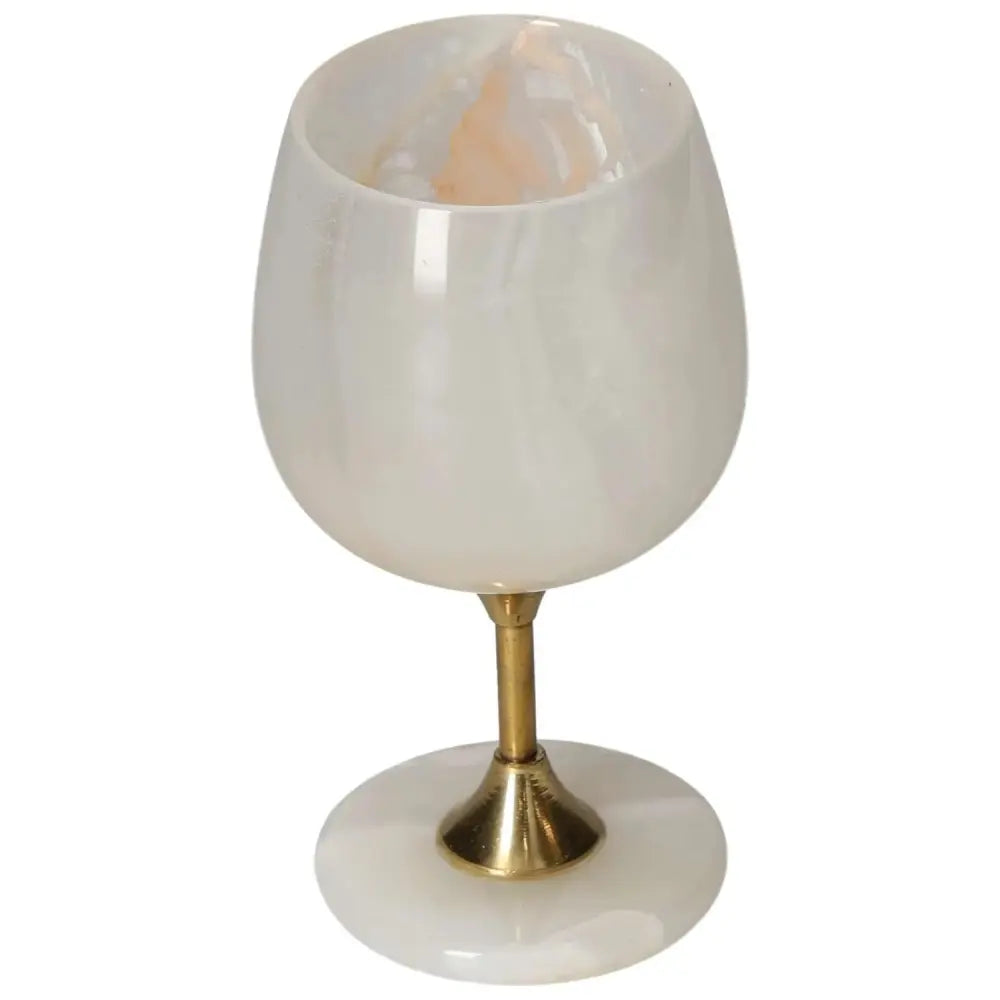 Elegant onyx wine glass with unique off-white color and veining, featuring a polished finish and sophisticated brass stem.