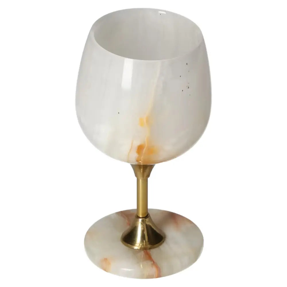 Elegant off-white onyx wine glass with unique veining and gold stem, perfect for sophisticated occasions and fine drinking experiences.