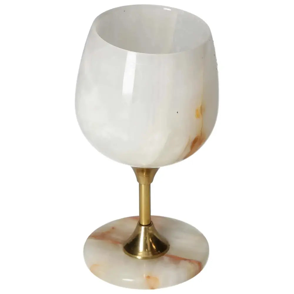 Elegant onyx wine glass with white marbled texture and golden stem, perfect for adding sophistication to fine dining experiences.