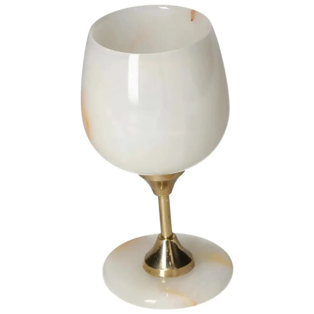 Exquisite onyx wine glass with a polished off-white surface and gold stem, showcasing unique veining and elegant design.