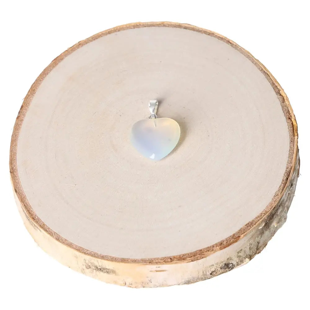Opalite Heart Pendant 15mm showcasing ethereal glow on wood display, symbolizing love and compassion, perfect gift idea.